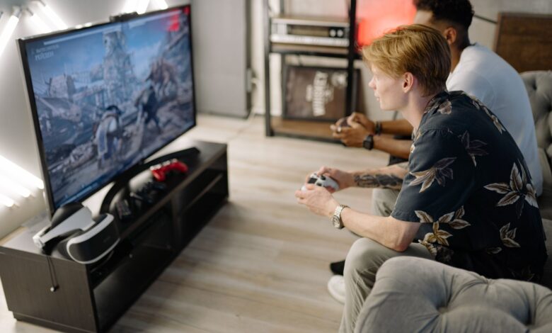 Two friends immersed in playing video games together in a cozy living room.