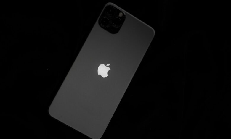 Close-up of a sleek smartphone featuring the iconic Apple logo against a black background.