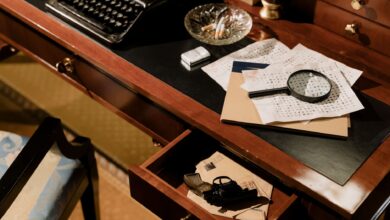 A moody vintage detective's desk with typewriter, magnifying glass, and secret documents.