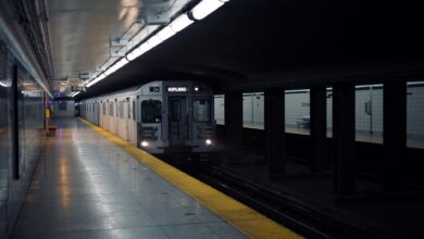 Toronto subway train approaching Dundas station platform in a dimly lit setting.