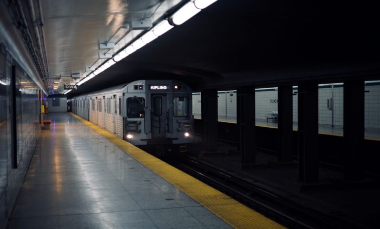 Toronto subway train approaching Dundas station platform in a dimly lit setting.
