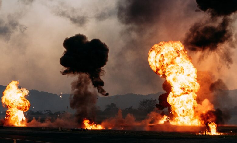 Intense fireball explosions with thick smoke in an outdoor setting. Captured during the day.