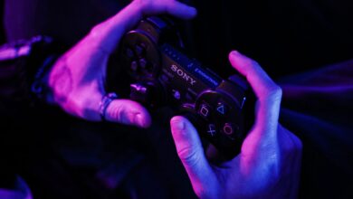 Hands grasping a gaming controller in a purple-lit room, highlighting immersive play.