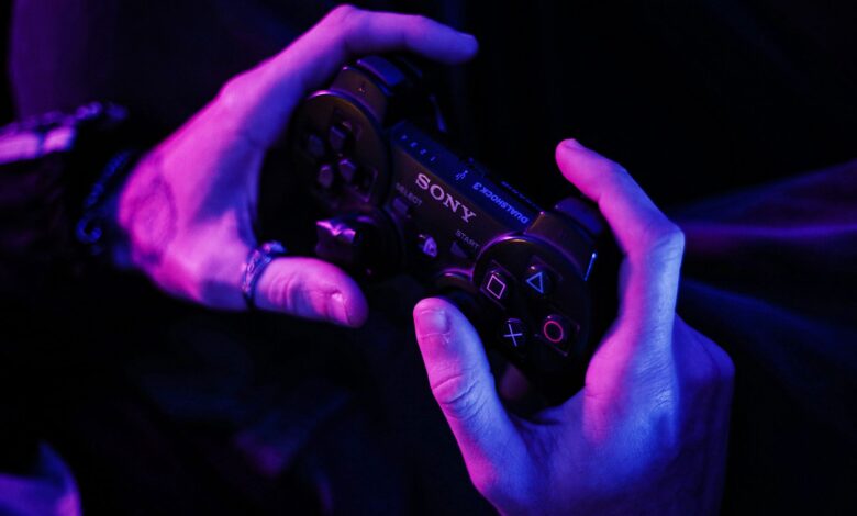 Hands grasping a gaming controller in a purple-lit room, highlighting immersive play.