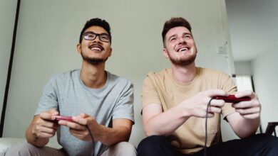 Two men happily playing video games in a modern living room.