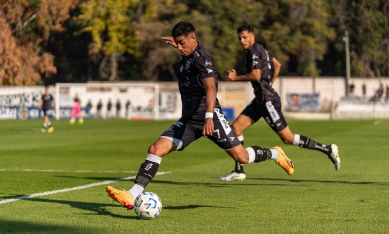 Dynamic action shot of footballers on the field during an outdoor game, showcasing sportsmanship and movement.
