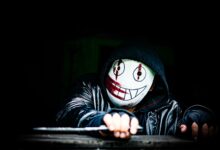 A mysterious figure wearing a creepy smiling mask in a dark setting, creating an eerie atmosphere.