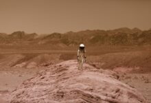 Astronaut walking on a barren, Mars-like desert landscape, depicting adventure and exploration.
