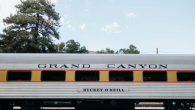 Side view of a vintage Grand Canyon Railway passenger car under a clear sky.