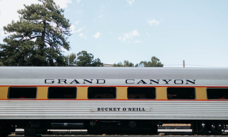 Side view of a vintage Grand Canyon Railway passenger car under a clear sky.