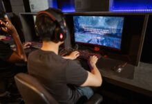 Two gamers immersed in a video game with high-tech equipment and vibrant gaming setup.