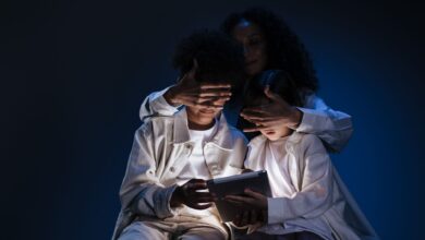 A mother oversees her children using a tablet, emphasizing safety and supervision in digital media use.