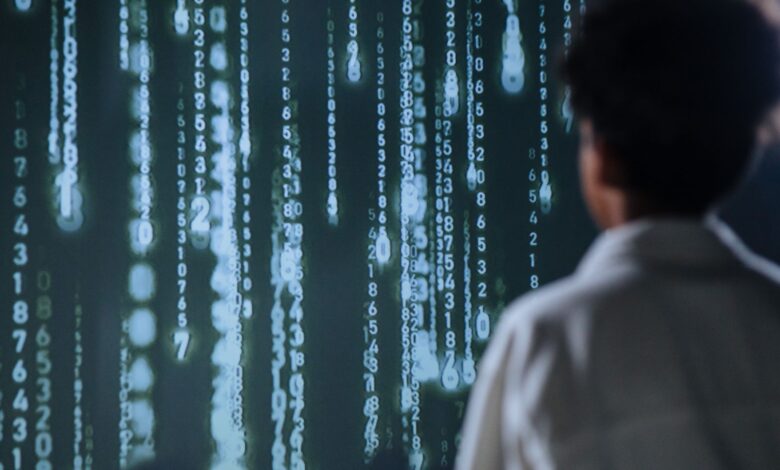 An individual viewing glowing numbers on a screen, symbolizing technology and data.