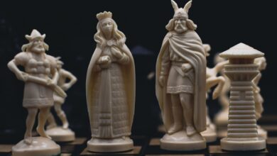Detailed close-up of intricately carved chess pieces on a chessboard, evoking a medieval theme.