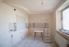 Spacious kitchen under renovation with ladder and tools, showcasing a fresh new design.