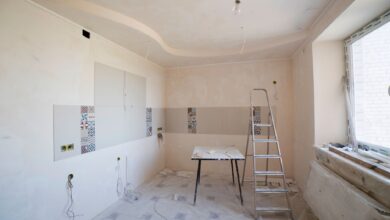 Spacious kitchen under renovation with ladder and tools, showcasing a fresh new design.