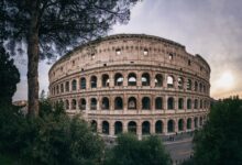 Captivating wide-angle shot of Rome's iconic Colosseum with a serene sunset backdrop.