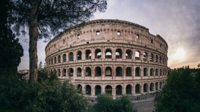 Captivating wide-angle shot of Rome's iconic Colosseum with a serene sunset backdrop.