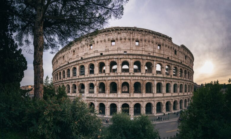 Captivating wide-angle shot of Rome's iconic Colosseum with a serene sunset backdrop.