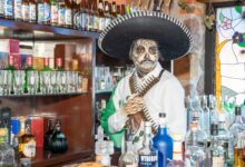 Colorful Day of the Dead themed bar setting in Ciudad de México with traditional attire.