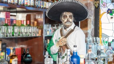 Colorful Day of the Dead themed bar setting in Ciudad de México with traditional attire.