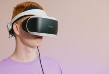 A young caucasian man wearing VR glasses, experiencing virtual reality.