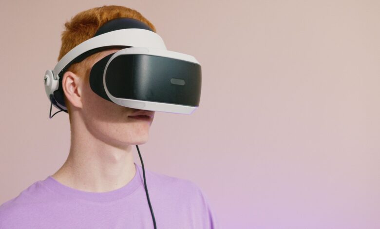 A young caucasian man wearing VR glasses, experiencing virtual reality.