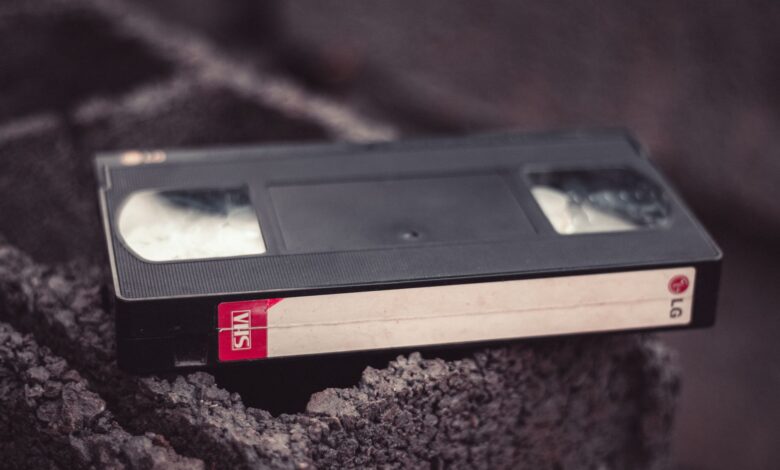 Close-up of a vintage VHS tape resting on a textured surface, offering nostalgic appeal.