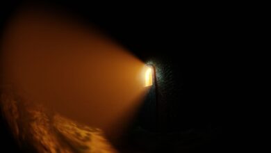 Atmospheric stone corridor with a glowing light beam creating a dramatic shadow.