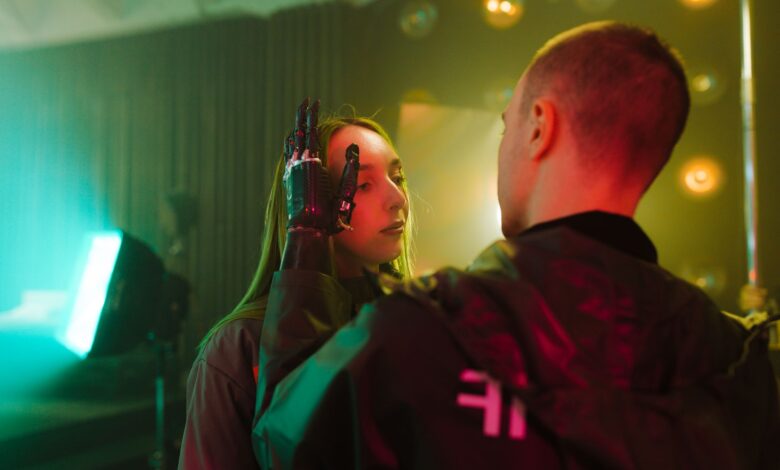 A man with a prosthetic hand gently touches a woman's face in a cyberpunk setting.