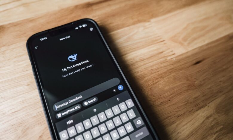 Close-up of a smartphone showing a chat app interface on a wooden table.