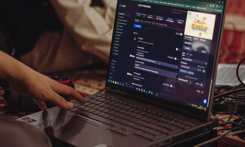 A person setting up a live stream on a laptop, emphasizing technology and connectivity.