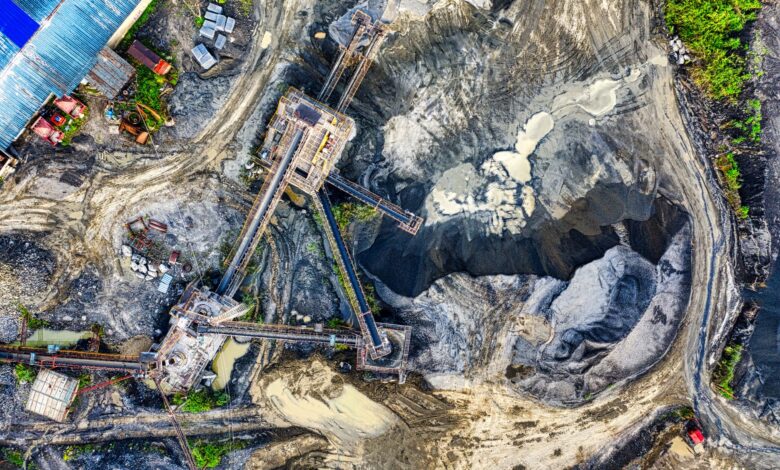 Top-down drone shot of an industrial mining site in Rumpin, West Java, showing machinery and excavation.