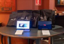 A promotional setup showcasing TCL tablets and branded gift bags on a round table indoors.
