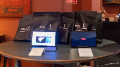 A promotional setup showcasing TCL tablets and branded gift bags on a round table indoors.