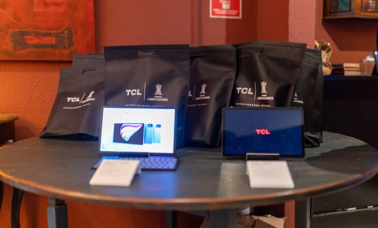 A promotional setup showcasing TCL tablets and branded gift bags on a round table indoors.