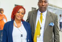 Elegant African couple attending a business conference in professional attire, showcasing cooperation and networking.