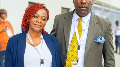 Elegant African couple attending a business conference in professional attire, showcasing cooperation and networking.