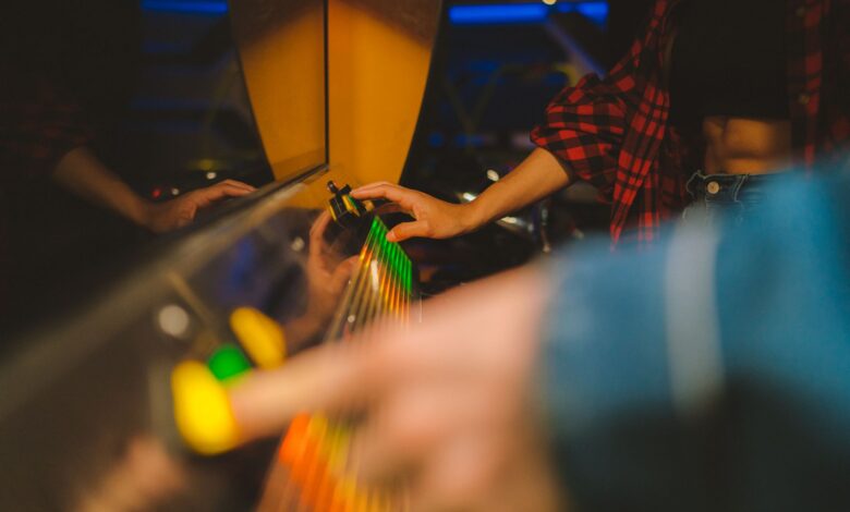 Woman in a checkered shirt playing an arcade game with colorful buttons. Engaging and fun atmosphere.