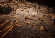 Close-up of a detailed miniature construction site showcasing a quarry with machinery and structures.