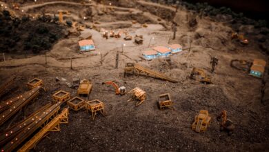 Close-up of a detailed miniature construction site showcasing a quarry with machinery and structures.