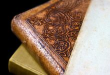 Detailed close-up of an antique leather bound book with ornate engraving and aged paper.
