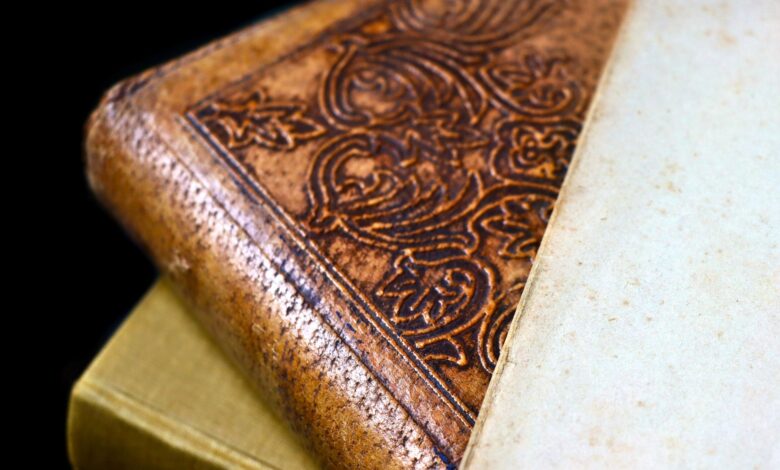 Detailed close-up of an antique leather bound book with ornate engraving and aged paper.