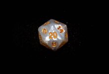 Close-up of a d20 die with glowing numbers against a dark background, symbolizing luck in role-playing games.