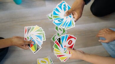 A group of friends enjoying a game of Uno, showcasing colorful cards and hands.