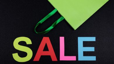 Bright sale text with green shopping bag on black background, perfect for promotions.