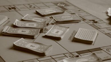 Close-up of board game with play money in sepia tone, focusing on strategic play.