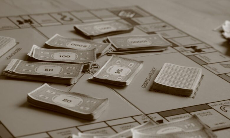 Close-up of board game with play money in sepia tone, focusing on strategic play.