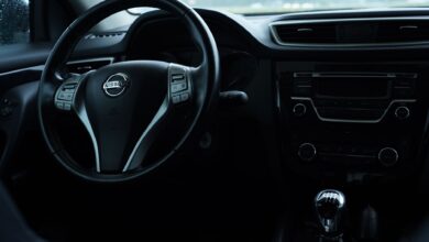 Dark interior view of a Nissan car featuring the steering wheel and dashboard details.