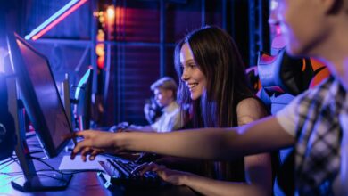 Group of teenagers happily engaged in gaming at a computer setup indoors.